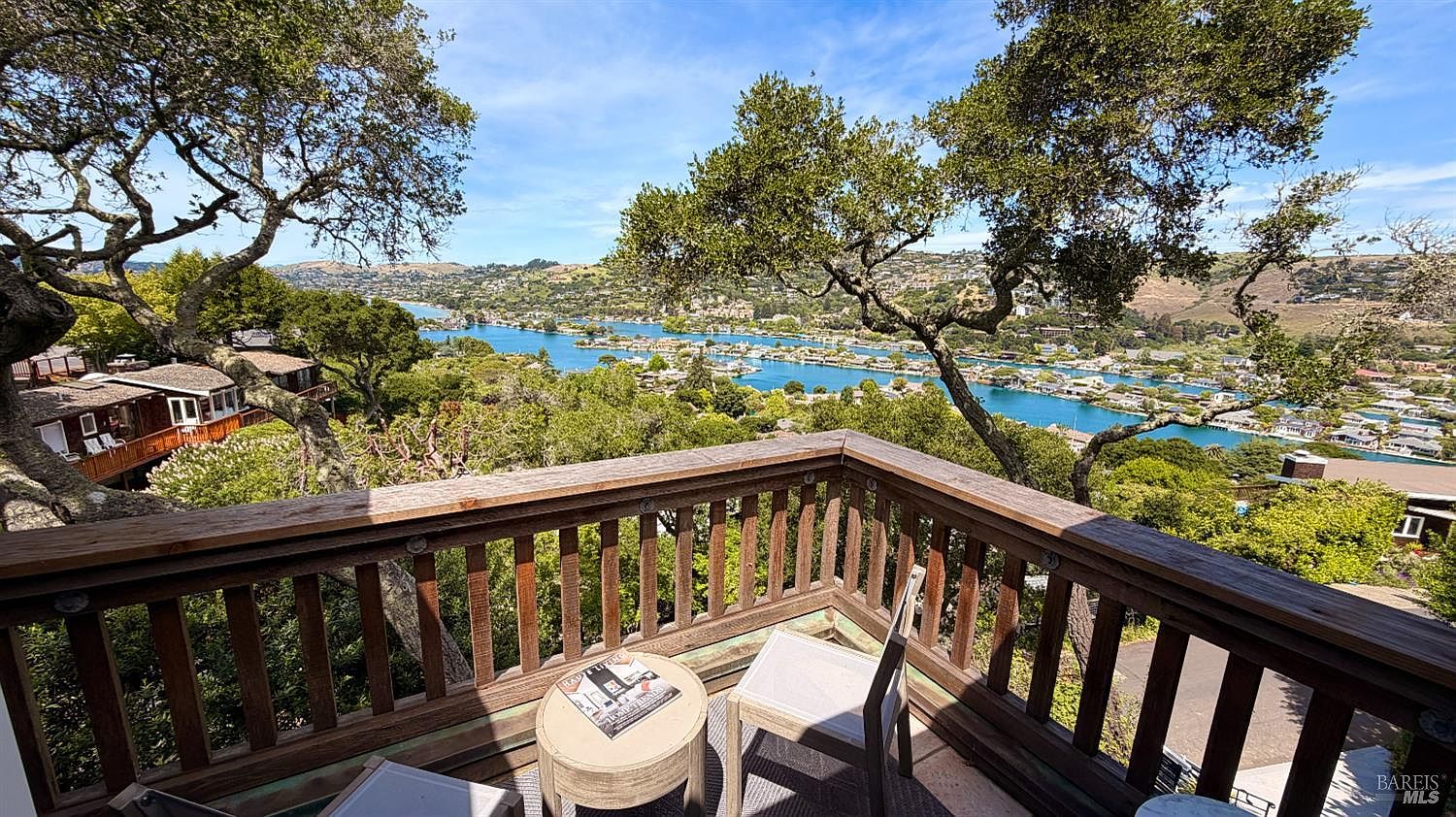 The deck of 45 Bella Vista with Belvedere harbor and Tiburon hills framed by mature oaks